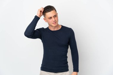 Young caucasian man isolated on white background having doubts while scratching head