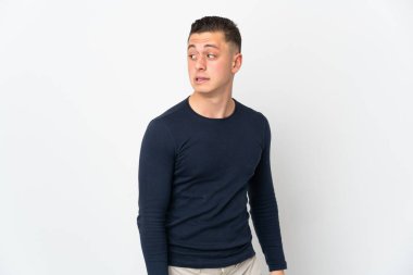 Beyaz arka planda izole edilmiş genç beyaz adam şüpheli hareketler yapıyor.