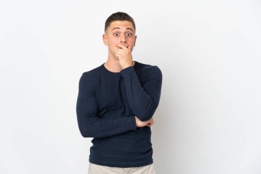 Beyaz arka planda izole genç beyaz adam şaşırdı ve şaşırdı