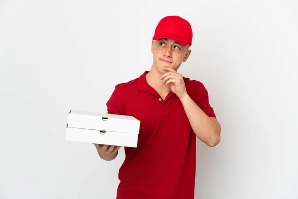 ピザ配達男ともに仕事の制服ピザボックスを拾う隔離された白い背景に疑問と思考を持っている — ストック写真