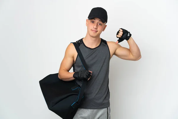 Young sport caucasian man with bag isolated on white background showing thumb down with negative expression