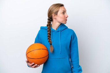 Beyazların arka planında izole bir şekilde basketbol oynayan beyaz bir kadın.