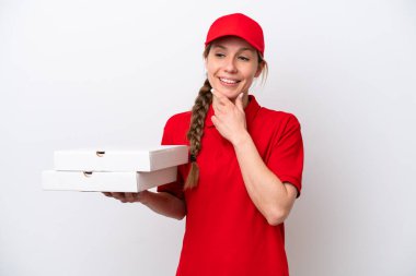Pizza teslimatçısı kadın iş üniformalı beyaz arka planda izole edilmiş pizza kutuları alıyor ve gülümsüyor.