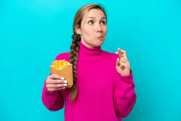 Young Caucasian Woman Holding Fried Chips Isolated Blue Background Fingers — стоковое фото