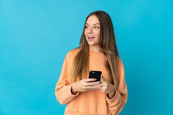 Νεαρή Λιθουανή Γυναίκα Απομονωμένη Μπλε Φόντο Χρησιμοποιώντας Κινητό Τηλέφωνο Και — Φωτογραφία Αρχείου