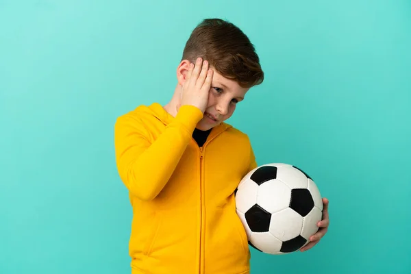 Roodharige Kind Spelen Voetbal Geïsoleerd Blauwe Achtergrond Met Hoofdpijn — Stockfoto