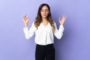 Mor arka planda Zen pozu almış beyaz bir kadın.