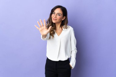 Mor arka planda izole edilmiş beyaz kadın parmaklarıyla beşi sayıyor.