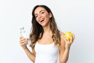 Beyaz arka planda bir elma ve bir şişe suyla izole edilmiş beyaz bir beyaz kadın.