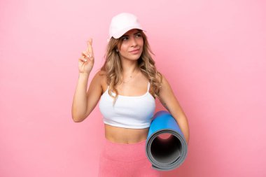 Genç sporcu kadın yoga derslerine giderken parmaklarını çapraz yapıp en iyisini diliyor.