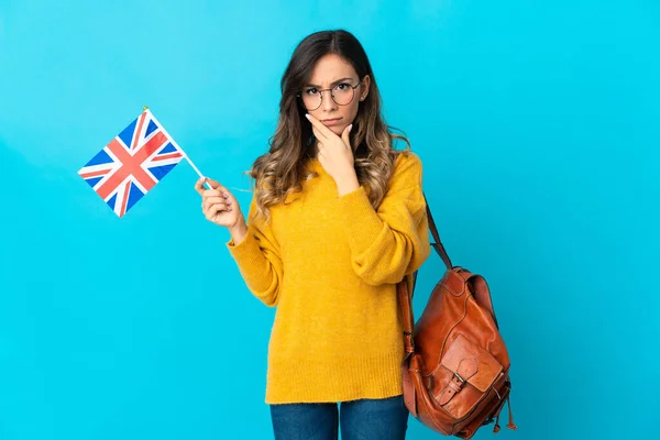 Молодая Латиноамериканка Держащая Флаг Великобритании Изолированная Синем Фоне Думает — стоковое фото