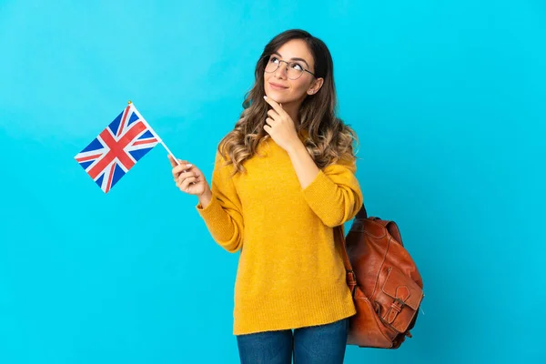 Mladá Hispánka Drží Vlajku Spojeného Království Izolované Modrém Pozadí Dívá — Stock fotografie