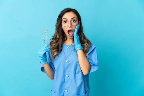 Zahnärztin Hält Werkzeug Über Isoliert Auf Blauem Hintergrund Mit Überraschung — Stockfoto