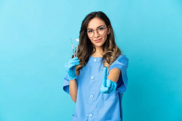 Zahnärztin Hält Werkzeug Über Isoliert Auf Blauem Hintergrund Und Zeigt — Stockfoto