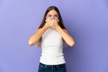 Genç Litvanyalı kadın mor arka planda izole edilmiş, ağzı elleriyle kapatıyor.
