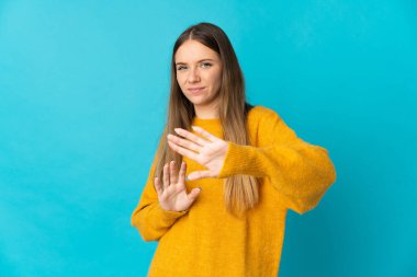Genç Litvanyalı bir kadın mavi arka planda izole edilmiş.
