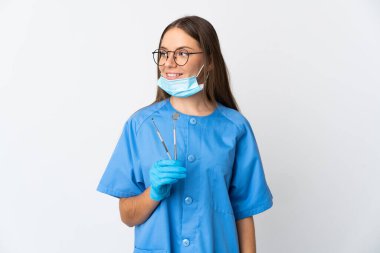 Litvanyalı kadın diş hekimi arka planda izole edilmiş araçları tutuyor.