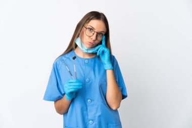 Litvanyalı kadın diş hekimi izole bir arka plan üzerinde aletler tutuyor.