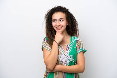 Beyaz arka planda izole edilmiş genç bir Arap kadın yan bakıyor ve gülümsüyor.