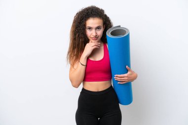 Genç Arap spor kadını yoga derslerine giderken beyaz arka planda izole edilmiş bir minder tutuyor.