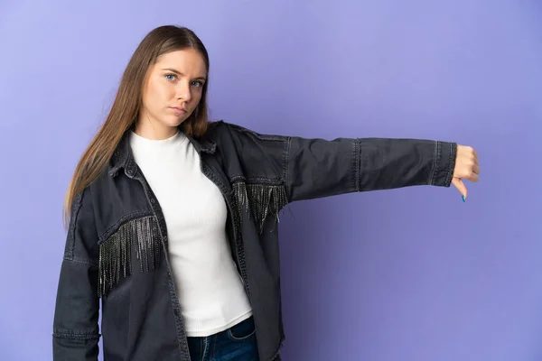 紫の背景に孤立した若いリトアニア人女性は否定的な表現で親指を下に示す — ストック写真