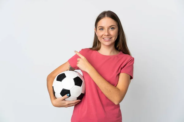 年轻的立陶宛女子 背靠白色背景 手拿着足球 指向侧边 — 图库照片