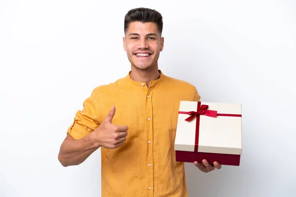Young Caucasian Man Holding Gift Isolated White Background Thumbs Because — Stock Photo, Image