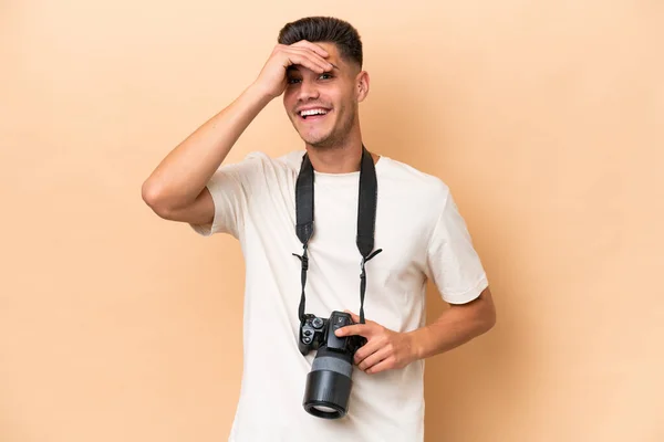 年轻的摄影师高加索人被米色背景隔离 手拉手遥望远方 寻找什么东西 — 图库照片