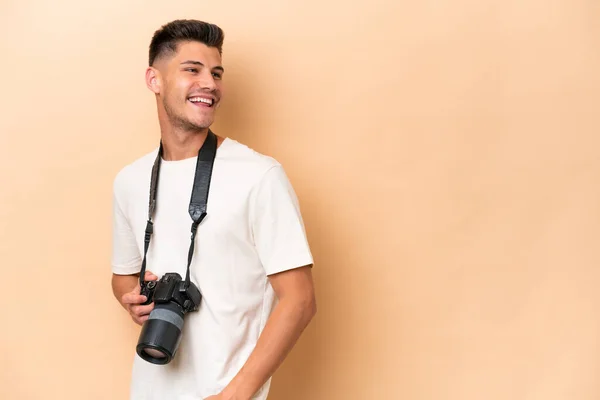 Νεαρός Φωτογράφος Καυκάσιος Άνδρας Απομονωμένος Μπεζ Φόντο Σταυρωμένα Χέρια Και — Φωτογραφία Αρχείου
