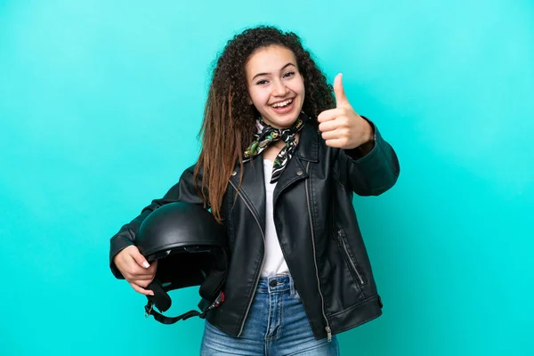 若いですアラブ女性とともにオートバイヘルメット隔離上の青の背景で親指アップ何か良いことが起こっているので — ストック写真