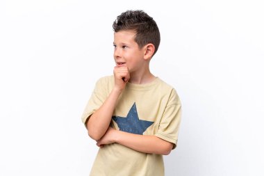 Beyaz arka planda izole edilmiş küçük beyaz çocuk yana bakıyor ve gülümsüyor.