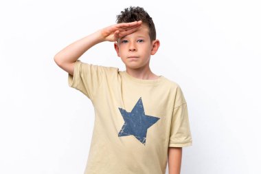 Beyaz arka planda izole edilmiş küçük beyaz çocuk mutlu bir ifadeyle selamlıyor.