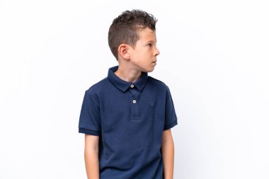 Beyaz arka planda izole edilmiş beyaz çocuk yan tarafa bakıyor.