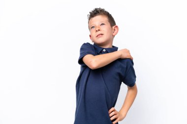 Beyaz arka planda izole edilmiş küçük beyaz çocuk çabaladığı için omuz ağrısı çekiyor.