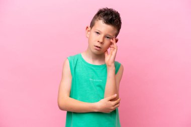 Little caucasian boy isolated on pink background with headache
