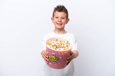 Beyaz arka planda izole edilmiş küçük beyaz çocuk elinde koca bir kova patlamış mısır tutuyor.