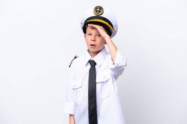 Küçük pilot çocuk beyaz arka planda izole edilmiş. Yan tarafa bakarken sürpriz jest yapıyor.