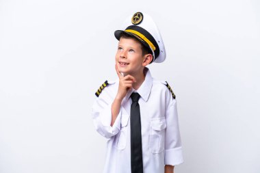 Küçük pilot çocuk beyaz arka planda izole edilmiş, yukarı bakarken bir fikir düşünüyor.