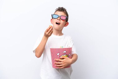 Beyaz arka planda üç boyutlu gözlüklü ve elinde koca bir kova patlamış mısır tutan beyaz tenli bir çocuk.