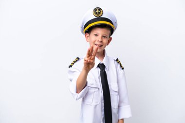 Küçük pilot çocuk beyaz arka planda izole edilmiş mutlu ve parmaklarıyla üçe kadar sayıyor.