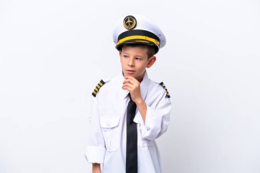 Küçük pilot çocuk beyaz arka planda izole edilmiş, yana bakıyor ve gülümsüyor.
