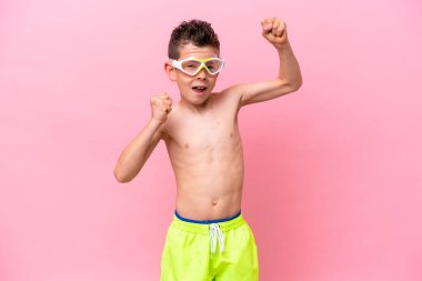 Pembe arka planda izole edilmiş dalış gözlüğü takan beyaz bir çocuk zaferi kutluyor.