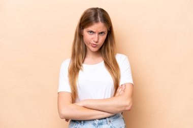 Beyazlı genç bir kadın bej arka planda izole edilmiş üzgün hissediyor.