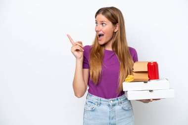 Beyaz arka planda izole edilmiş fast food tutan güzel sarışın kadın çözümü fark etmek için parmağını kaldırıyor.