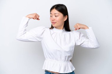 Beyaz arka planda izole edilmiş genç Çinli kadın güçlü bir jest yapıyor.