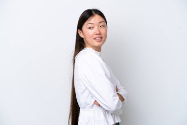 Beyaz arka planda izole edilmiş genç bir Çinli kadın yan bakıp gülümsüyor.