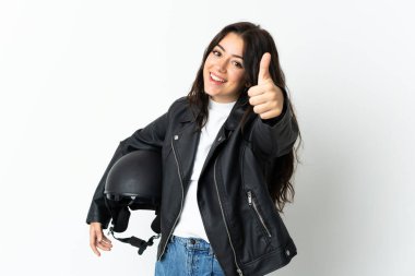 Beyaz arka planda izole edilmiş motosiklet kaskı tutan bir kadın. Başparmakları havada çünkü iyi bir şey oldu.