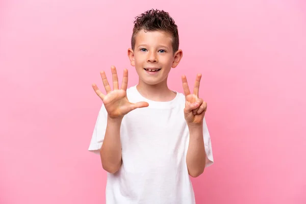 一个被粉色背景隔离的高加索小男孩用手指数到七 — 图库照片