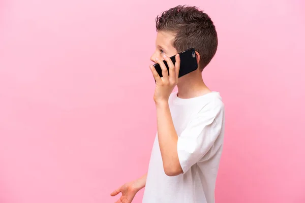Little Caucasian Boy Isolated Pink Background Keeping Conversation Mobile Phone — Stock Photo, Image