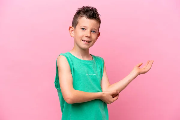 Little Caucasian Boy Isolated Pink Background Extending Hands Side Inviting —  Fotos de Stock